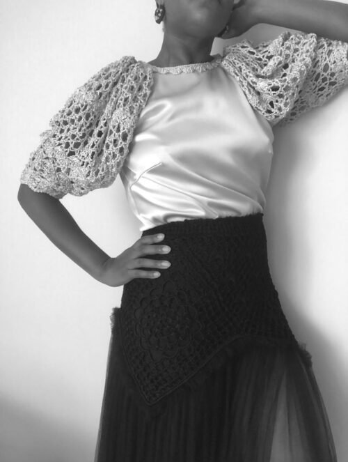 La camiseta Bloom de cuerpo en seda con mangas abullonadas tejido a mano en crochet  es el reflejo de la belleza y exuberancia del ganchillo.